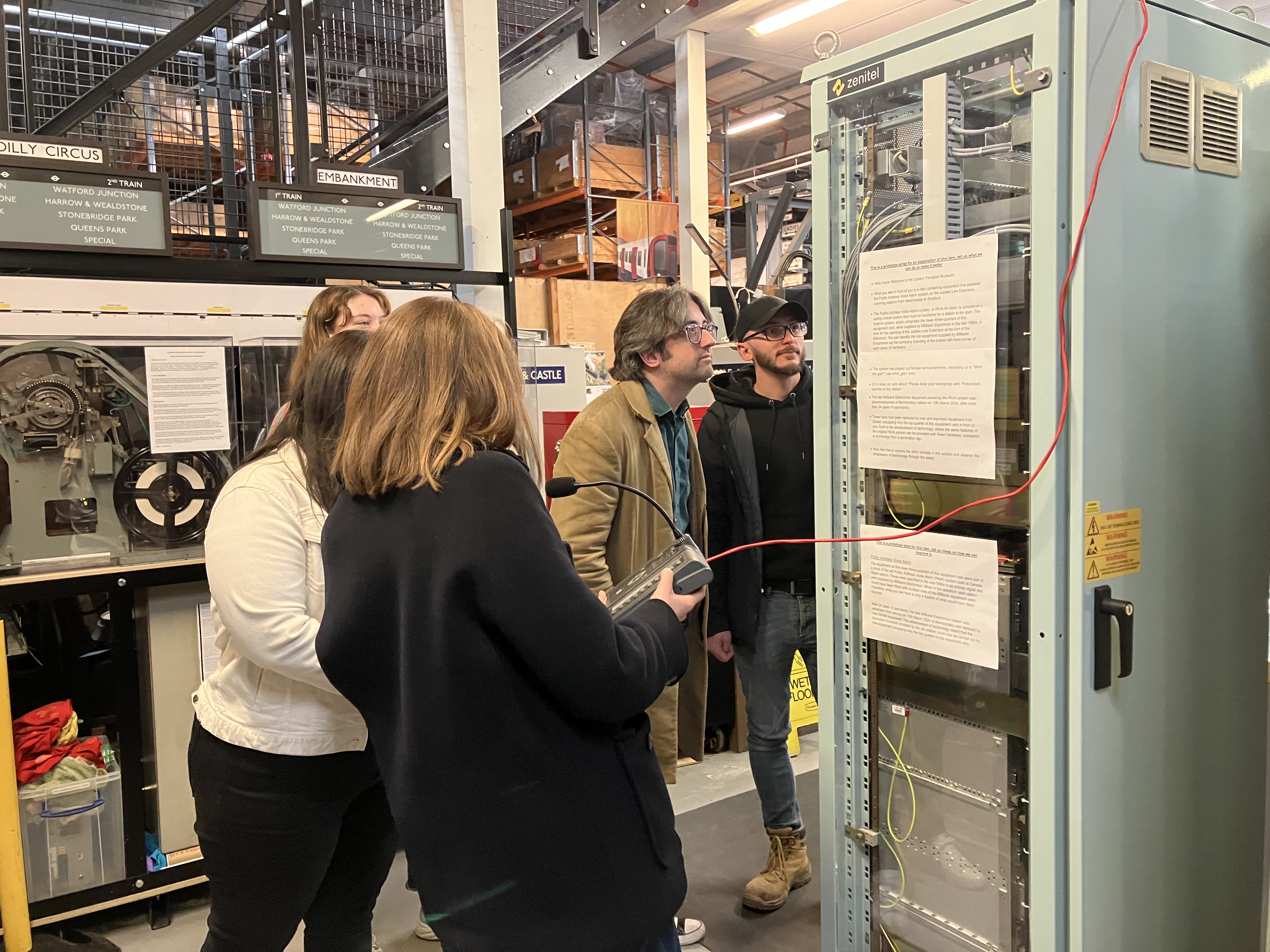 Group of people look at the Zenitel exhibit at the London Transport Museum